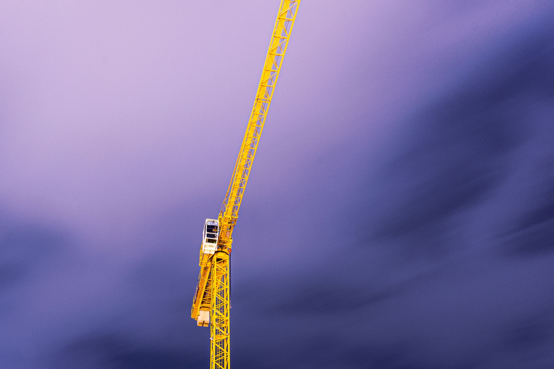 Crane against the evening sky over a construction site.
